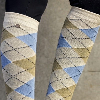 Meias argyle bege, azul claro e verde usadas numa pessoa com calças pretas.