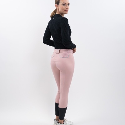 Modelo de costas com calças de equitação rosa e preta, camisola preta e ténis brancos em fundo branco