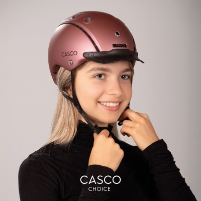 Capacete rosa metálico CASCO modelo CHOICE usado por mulher com camisola preta