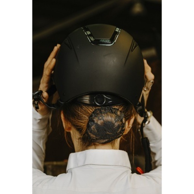 Capacete preto fosco visto de trás com pessoa de cabelo preso em rede preta e camisa branca