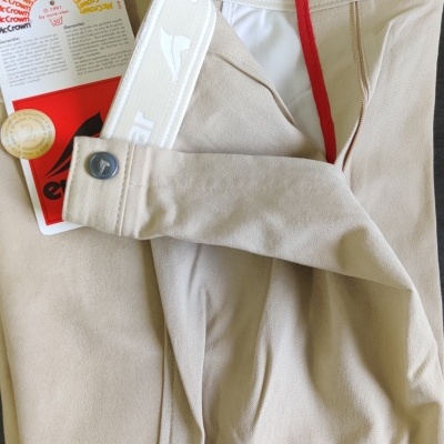 Calças bege robustas com detalhes em vermelho e branco, etiqueta EuroStar e cartão dourado