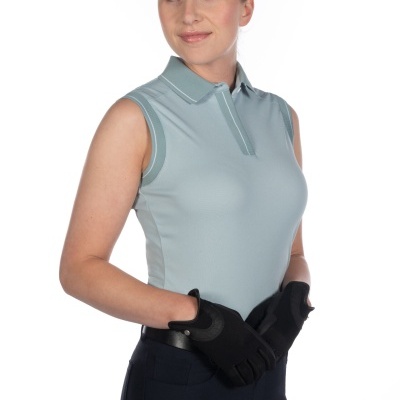 Mulher com camisa pólo cinza claro sem mangas, luvas pretas e calças escuras em fundo branco