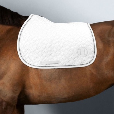 Manta de sela branca acolchoada com borda preta num cavalo castanho
