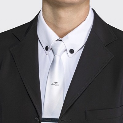 Homem com camisa branca gola abotoada, gravata branca com desenho, casaco preto com lapela
