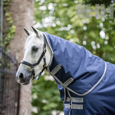 Cobertura para cavalo azul marinho com fitas cinzentas e etiquetas HORSEWARE IRELAND num cavalo branco
