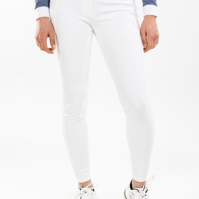 Calças brancas justas com cintura alta e botões, usadas por pessoa com camisola azul e sapatilhas brancas