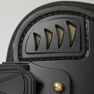 Detalhe de bota ou calçado preto com partes em plástico e elementos dourados