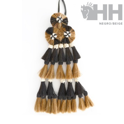 Acessório decorativo de fibras naturais bege e preto com franjas e círculos trançados.