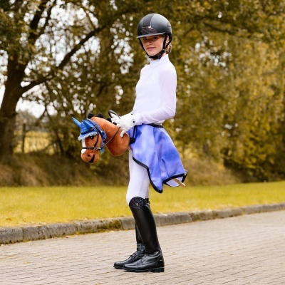 Criança com capacete e cavalo de peluche azul e castanho ao ar livre