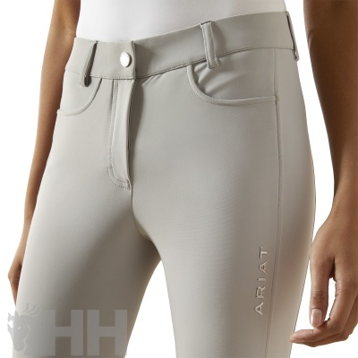 Calças justas cinza claro com botão prateado e logo ARIAT na perna