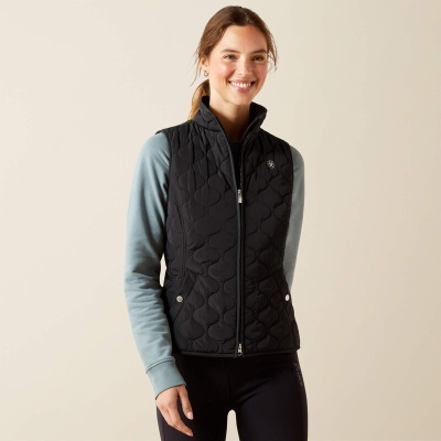 Colete acolchoado preto em modelo feminino sobre camisola azul clara