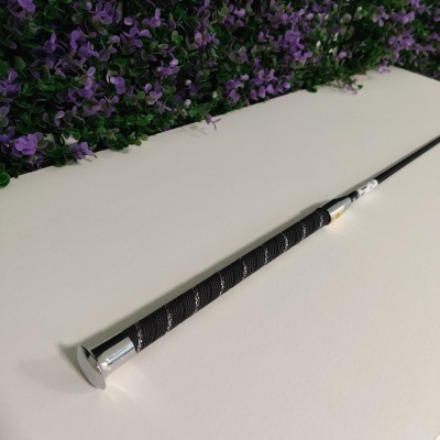 Vara de pesca com cabo preto e acabamento metálico sobre superfície branca