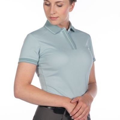 Mulher com polo azul claro e calças cinza escuro em fundo branco