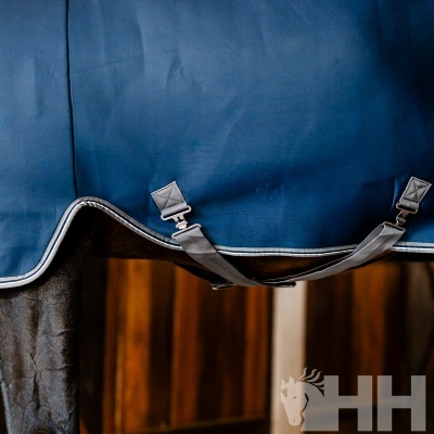 Cobertura azul para cavalo com franjas cinzentas e fivelas metálicas prateadas