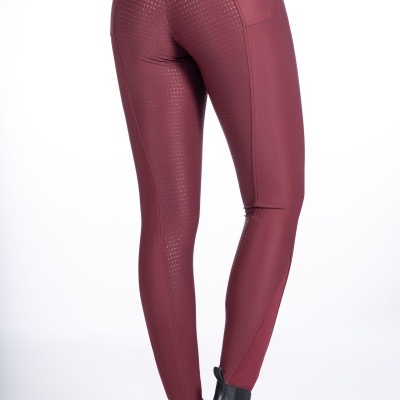 Calças de equitação vinho com texturização antiderrapante e botas pretas.