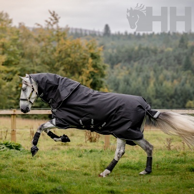 Cavalo cinza com manta preta com logo HH em campo verde