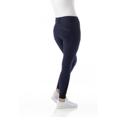 Calças azul escuro com bolsos trás usadas por pessoa com sapatilhas brancas e t-shirt branca