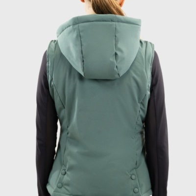 Colete verde com capuz acolchoado visto por trás, usado por pessoa com cabelo apanhado e roupa preta