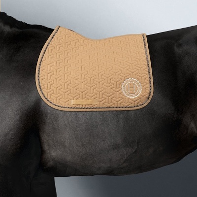 Tapete de sela bege com padrão geométrico sobre cavalo preto