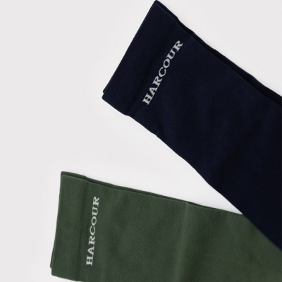 Duas mangas de tecido, uma verde e outra azul escuro, com a palavra HARCOUR em branco.