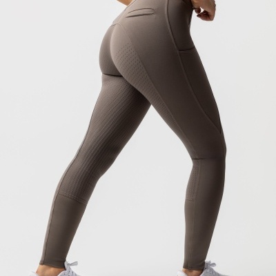Leggings cinzentas esportivas com bolsos e textura, usadas com sapatilhas brancas Puma.