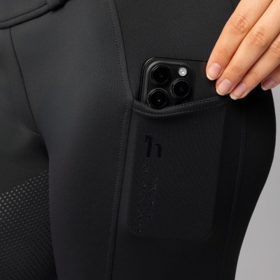 Calças pretas justas com bolso lateral e smartphone preto