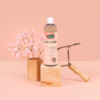 Frasco de produto Ravena Easy Shine, flores cor-de-rosa, vaso dourado e rolo de pintura com cabo de madeira sobre fundo cor-de-rosa