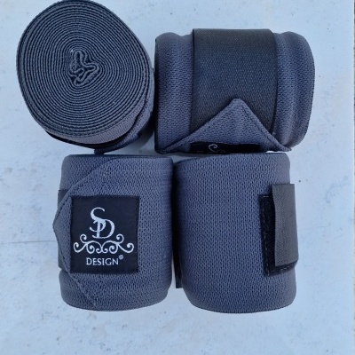 Quatro bandagens elásticas cinza escuro com etiquetas 'SD DESIGN' numa superfície clara com azulejos