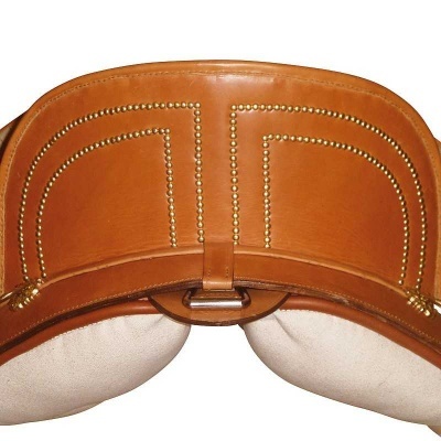 Sela de equitação em couro castanho claro com tachas douradas e assento almofadado bege