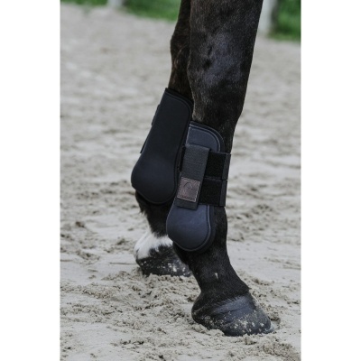 Perneiras de proteção pretas em perna traseira de cavalo castanho escuro