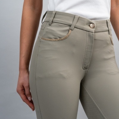 Calças justas bege com bolso e botão metálico, usadas por modelo com t-shirt branca.