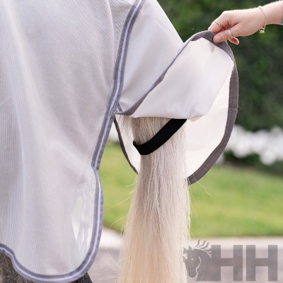 Capa branca para cavalo com bordas cinzentas e abertura para o rabo, sendo levantada por uma mão.