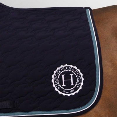 Tapete azul escuro acolchoado para sela de cavalo com bordas azuis claras e branco e logótipo HARCOUR.