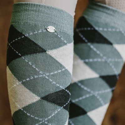 Meias de malha com padrão argyle verde, preto e branco com emblema metálico