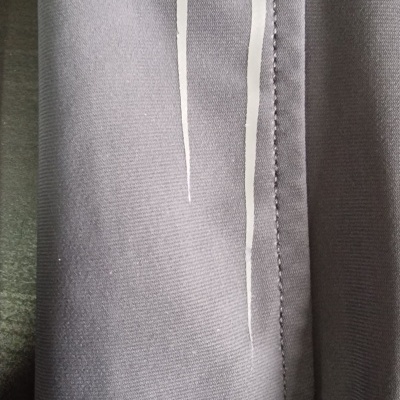 tecido cinza claro com costura e linhas brancas verticais