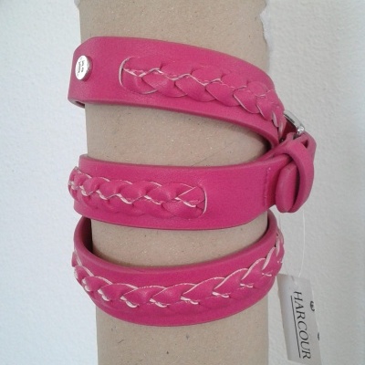 Pulseira rosa em couro sintético com costura branca e fivela, etiqueta HARCOUR.