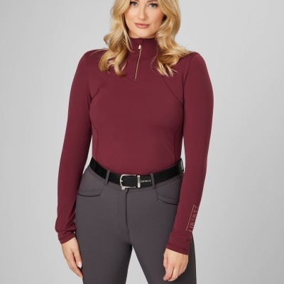 Mulher com camisola vinho de manga comprida e calças cinza escuro com cinto preto