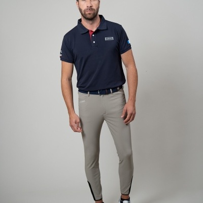 Homem de pé com roupa casual desportiva em fundo cinza