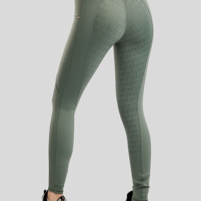 Leggings verdes desportivas com padrão perfurado, usadas com ténis cinzentos