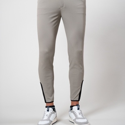 Calças justas cinza claro com detalhes pretos nas pernas usadas por homem com ténis cinza e branco
