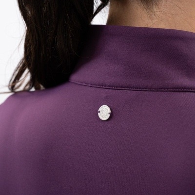 Peça de vestuário roxa com botão prateado na parte de trás