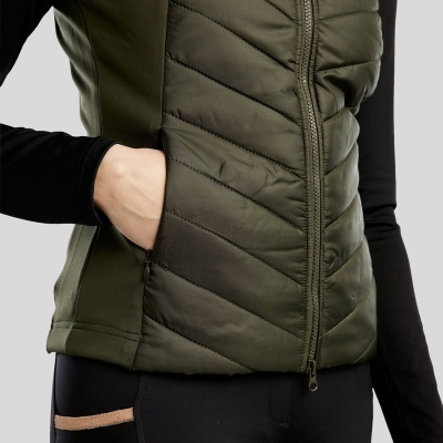 Colete acolchoado verde com fecho e bolso lateral, usado com roupa preta