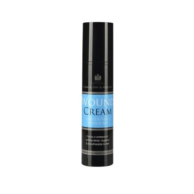 Frasco preto de creme com rótulo azul e texto WOUND CREAM
