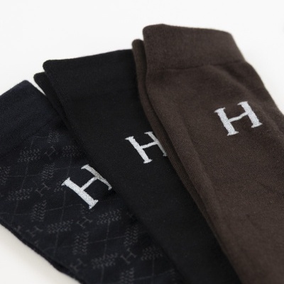 Três pares de meias castanho, preto e preto com padrão xadrez, com letra H branca bordada.