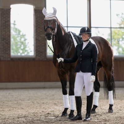 Cavaleira com cavalo em ambiente interno de equitação