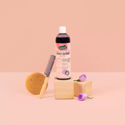 Frasco de produto Easy Shine, pente, esponja e flores sobre blocos de madeira e fundo rosa.