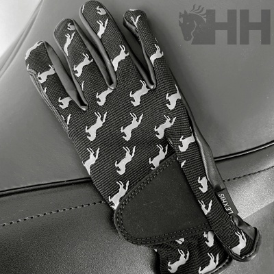 Luvas pretas com padrão de cavalos brancos sobre superfície de couro preto