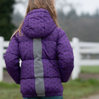 Casaco infantil roxo com padrão preto e faixa cinza nas costas, ao ar livre