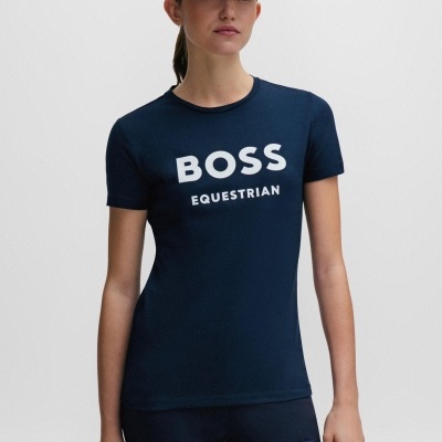 Modelo feminina com t-shirt, calças e boné azuis da linha BOSS Equestrian