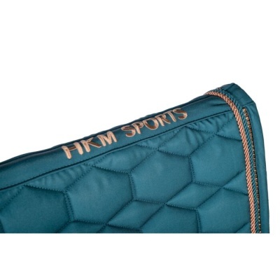 Detalhe de tecido acolchoado azul esverdeado com padrão hexagonal e borda de cordão laranja com texto HKM SPORTS bordado